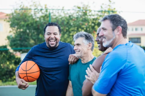 Multi-ethnic group of middle aged men playing basketball.