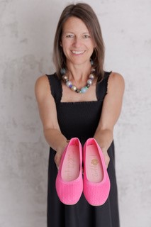 Lisa Carlin holding up Poppies, bright pink flats