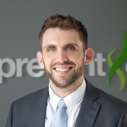 A very handsome man in a suit smiles for a work photo day session.