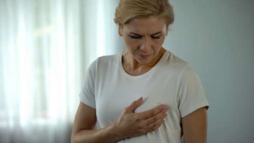 A woman holds her breast in her hand