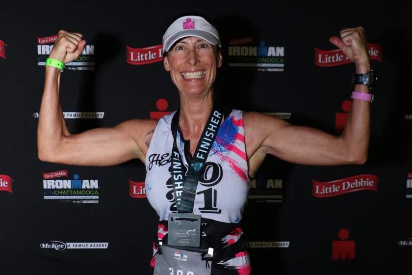 Marion in her racing uniform flexing her biceps