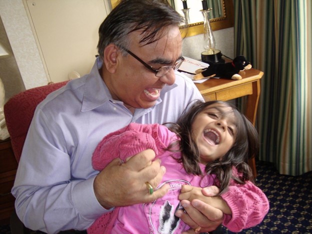 Emily as a little girl with her dad. Both are laughing.