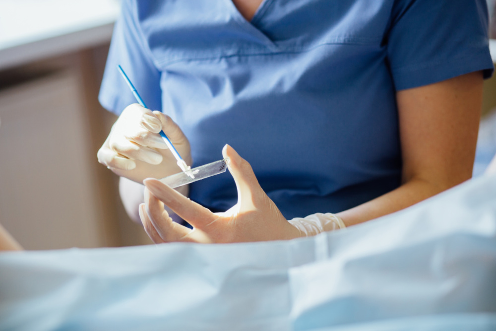 Health care provider takes samples from a patient’s cervix.