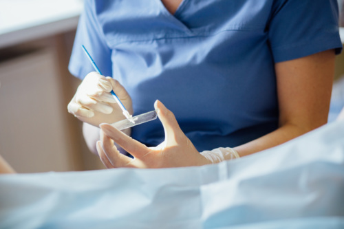 Health care provider takes samples from a patient’s cervix.