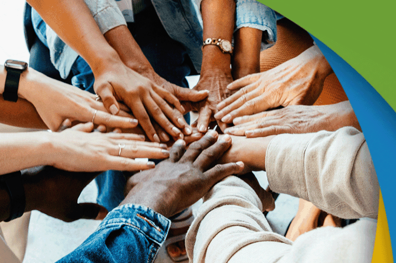 closeup image of diverse hands coming together as a team.