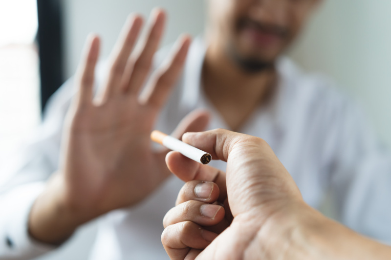 Man holds up his hand to refuse a cigarette.