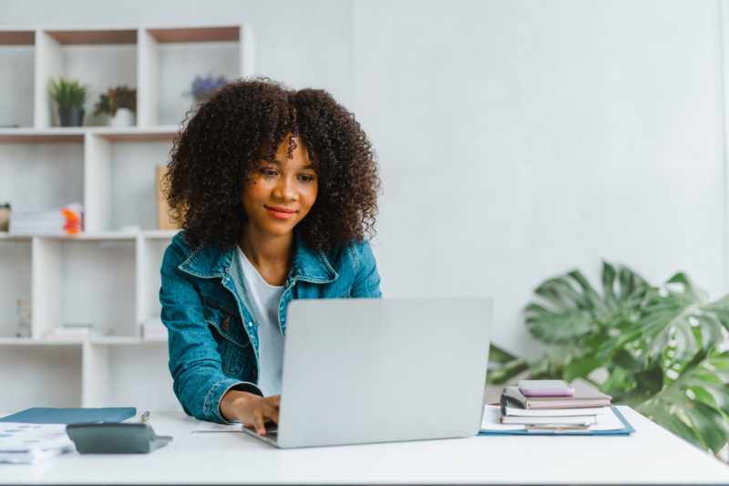 Woman soft smiling at her computer screen in an office.