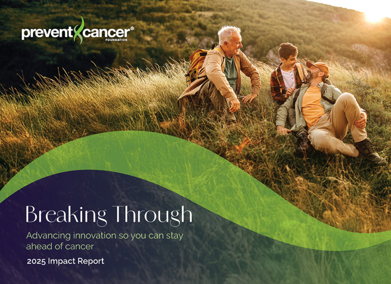 A senior man with his adult son and teen grandson are sitting on a grassy hill while a sun sets behind them.