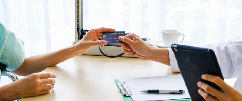 Woman handing over credit card.