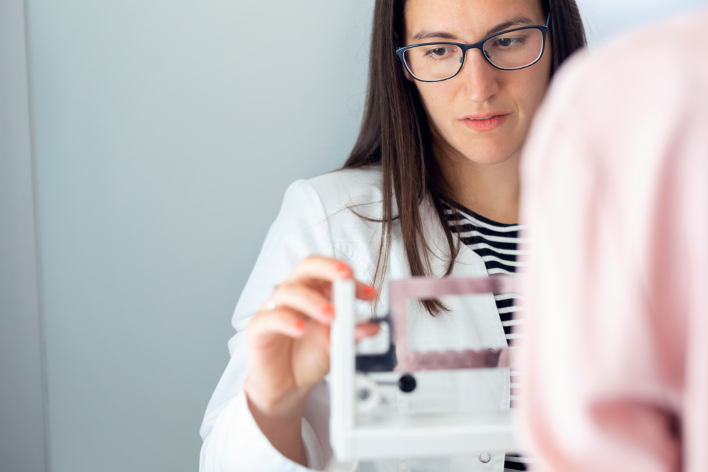 Female doctor checking a patient's weight.