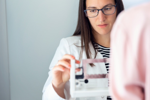 Female doctor checking a patient's weight.