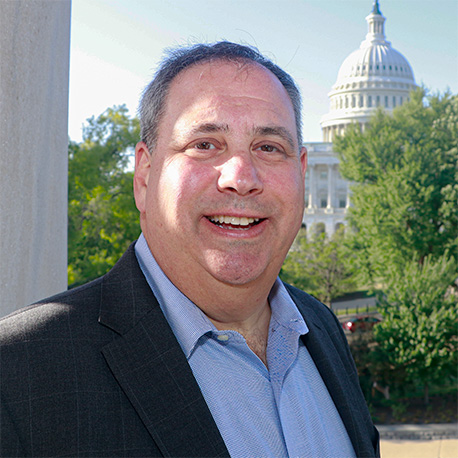 Headshot of Jon Nevett. The National Capitol can be seen in the background.