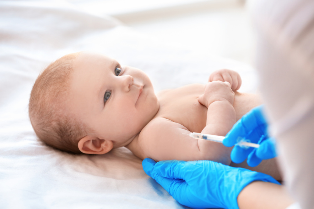 Doctor vaccinating baby in clinic.