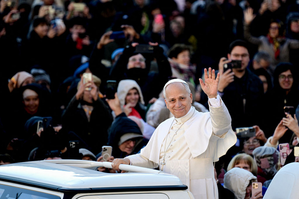 The Pope waves to an audience from the Pope Mobile.