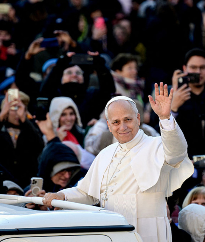 The Pope waves to an audience from the Pope Mobile.
